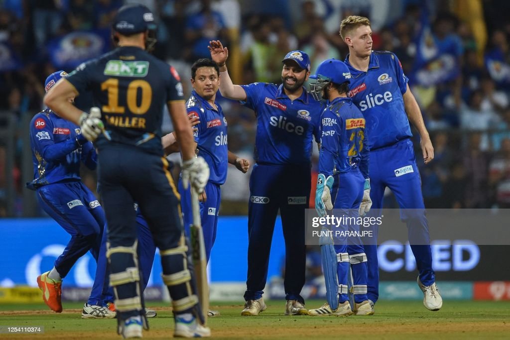 Mumbai Indians' players celebrate after the dismissal of Gujarat Titans' Vijay Shankar (not pictured) during the Indian Premier League (IPL) Twenty20 cricket match between MI vs GT at the Wankhede Stadium in Mumbai